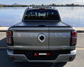 Load image into Gallery viewer, Rear view of GWM Cannon Alpha Roller Cover fitted to a vehicle overlooking a river