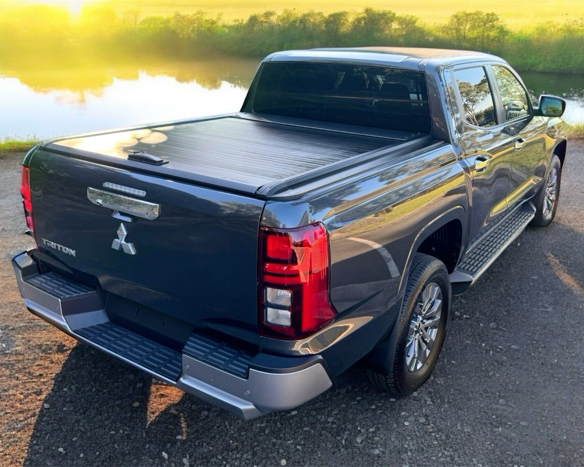 Rear view of a Mitsubishi MV Triton with an Akuma 4x4 Roller Cover fitted. Sunset in background