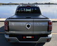 Load image into Gallery viewer, Rear view of GWM Cannon Alpha Roller Cover fitted to a vehicle overlooking a river
